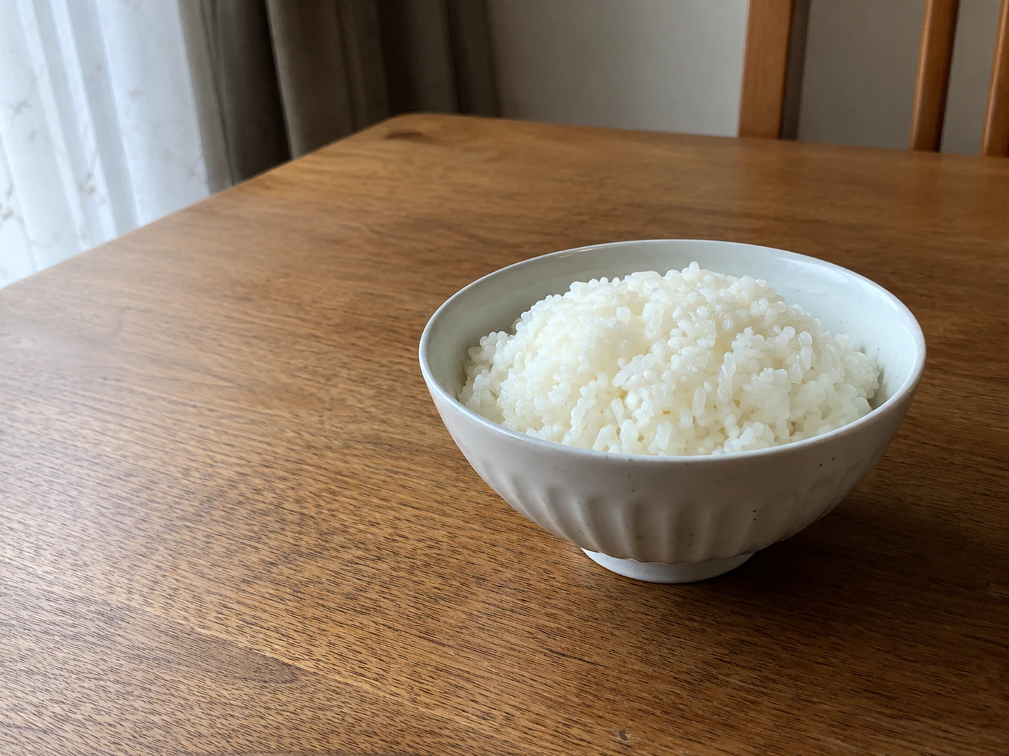 木の食卓に置かれた白ごはん